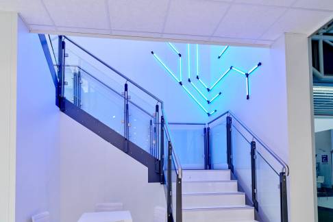 Leuchte für Leuchte bilden LIGEO Tubes Schaltkreise im Treppenhaus von einem Rutronik Messestand nach.